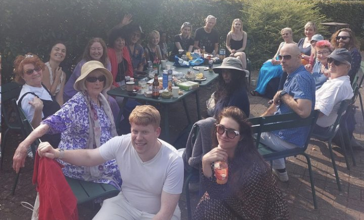 Members of London South & London North Branches sit around a picnic table at the annual picnic.