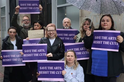 Photo shows Equity's Northern Ireland Committee holding 'Save The Arts Resist the Cuts' placards 